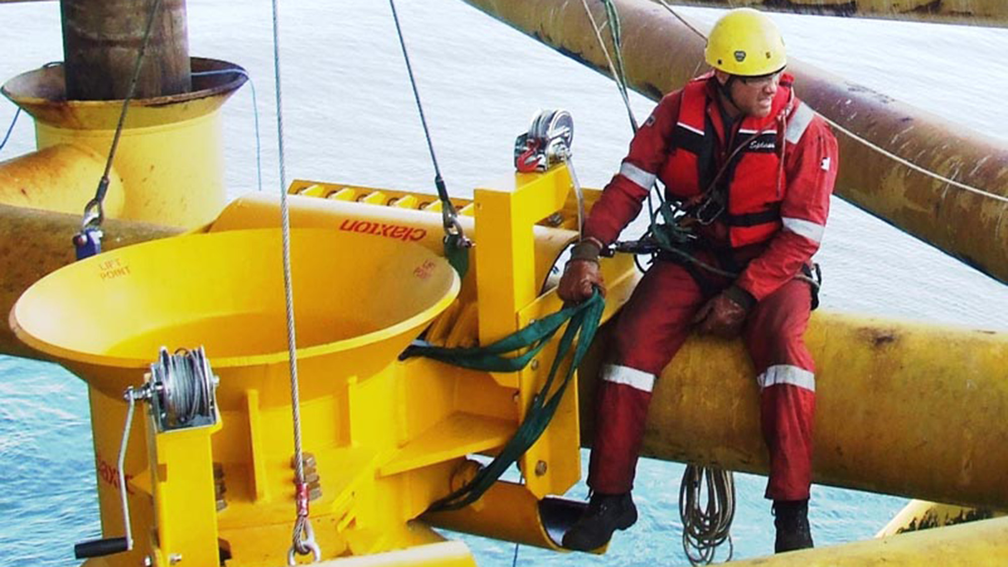 Man on rope installing riser centralizer on rig.