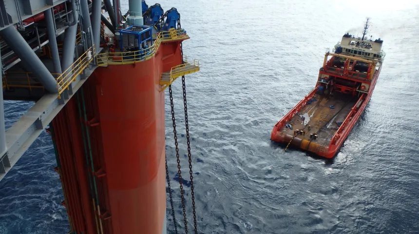 View from the top of a large steel structure onto the onto and an anchor handling vessel 