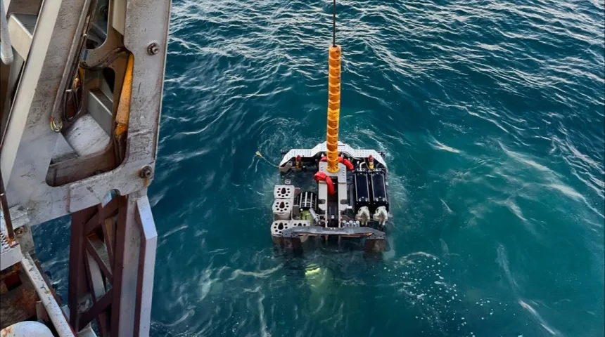 PROD deployment being lowered into the sea, with open ocean and a cloudy sky in the background
