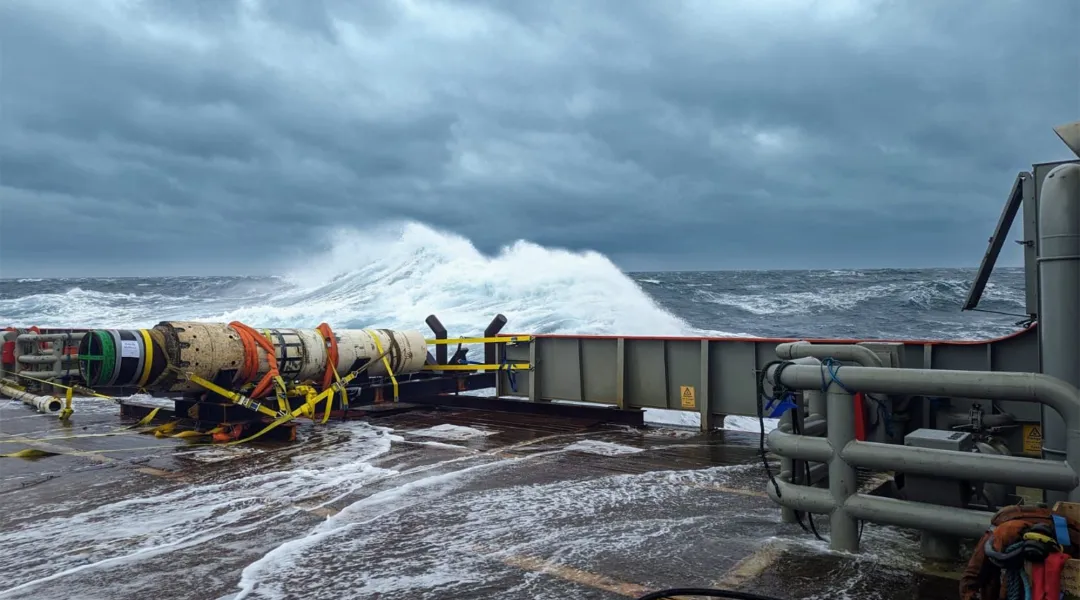 An old oil extraction pipe lays on the back deck of a boat after decommissioning, in rough North Sea conditions.
