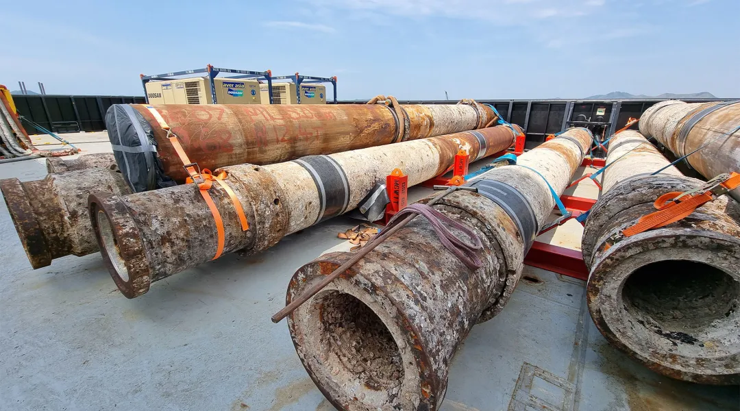 Old oil well conductors and lay on the back deck of a boat after being cut and decommissioned