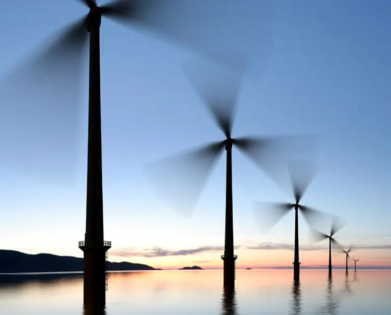 offshore wind turbines in silhouette at twilight, square frame